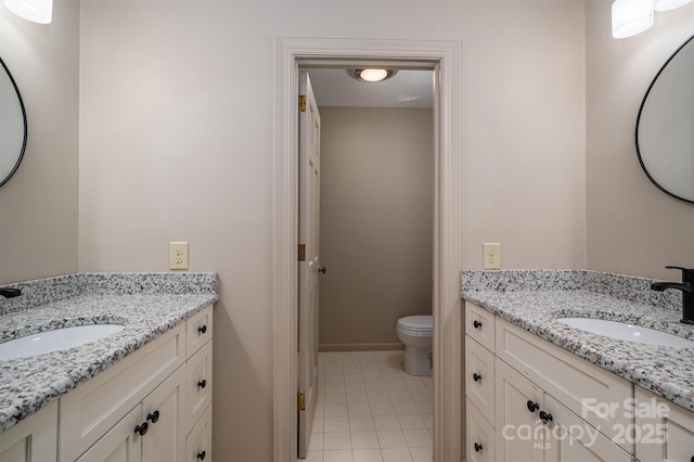 bathroom featuring two vanities, a sink, and toilet