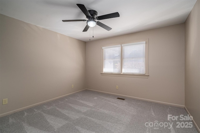 carpeted spare room with ceiling fan, visible vents, and baseboards