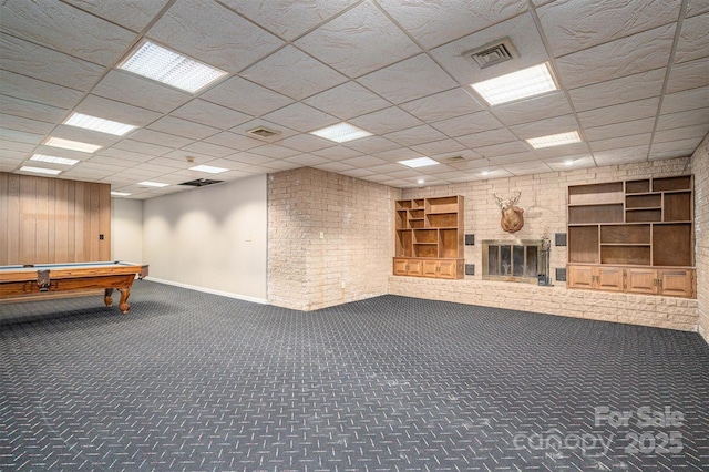 interior space featuring a brick fireplace, carpet flooring, visible vents, and built in features