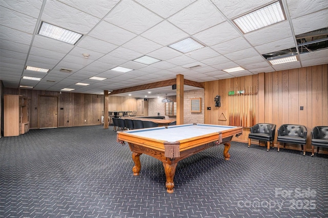 playroom with dark colored carpet, pool table, wooden walls, and a drop ceiling