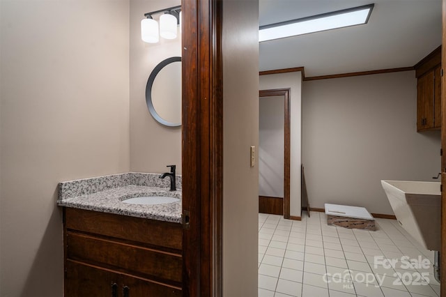 bathroom with ornamental molding, tile patterned flooring, vanity, and baseboards