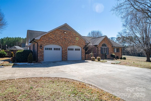 view of front facade with an attached garage, concrete driveway, and brick siding