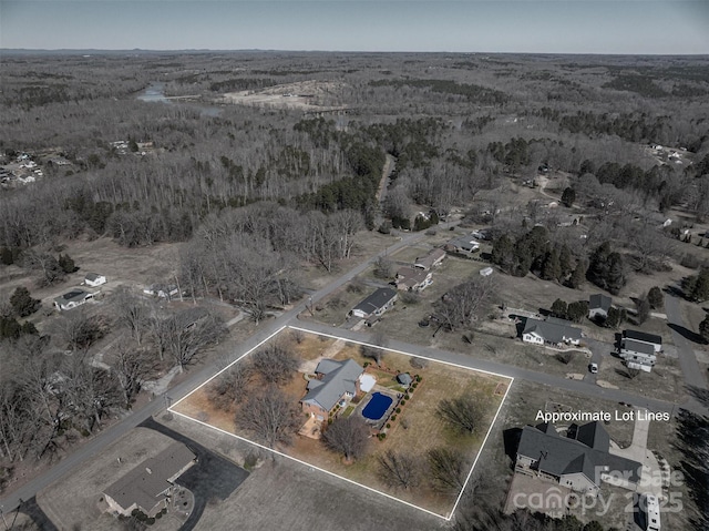 drone / aerial view featuring a wooded view