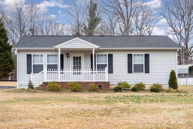 single story home featuring a front lawn, covered porch, and a shingled roof