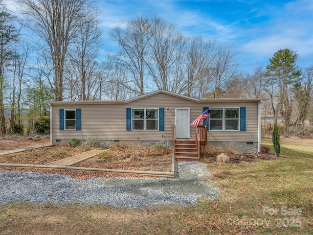 manufactured / mobile home featuring a front lawn and crawl space