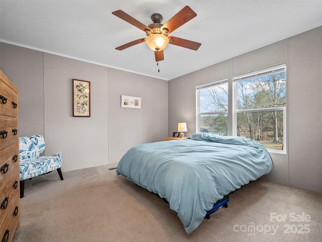 carpeted bedroom featuring ceiling fan and ornamental molding