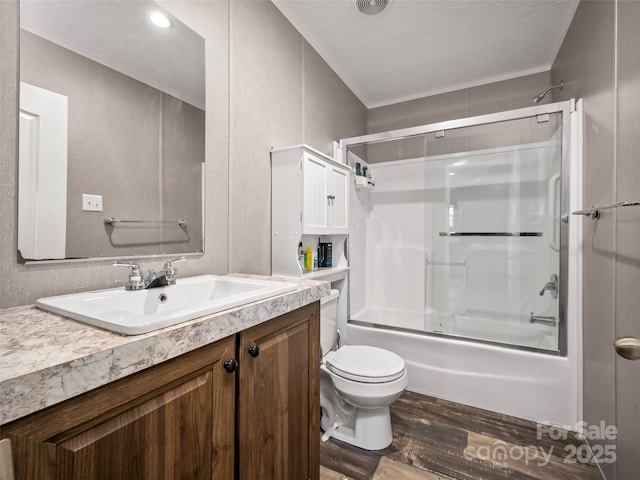 full bath featuring enclosed tub / shower combo, vanity, wood finished floors, and toilet