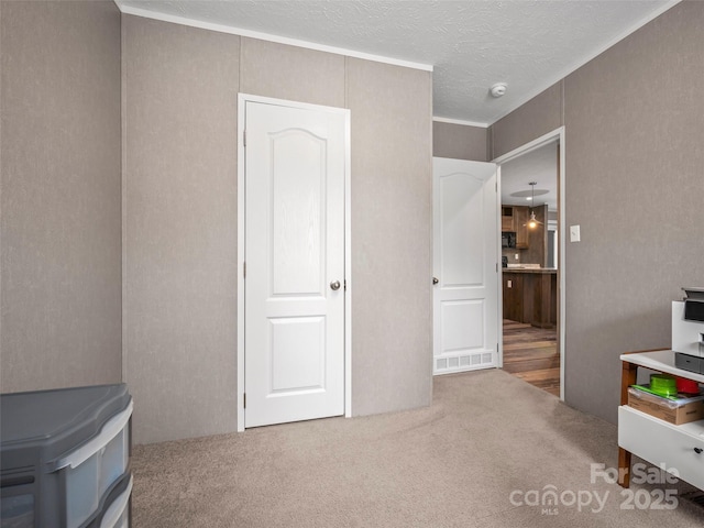 carpeted bedroom with a textured ceiling and crown molding