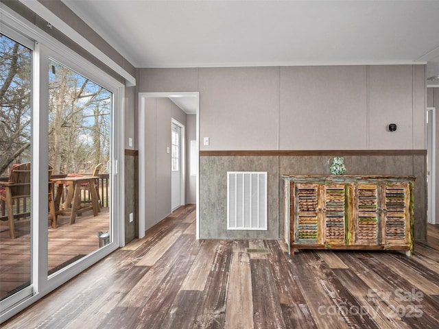 interior space with wainscoting, visible vents, and wood finished floors