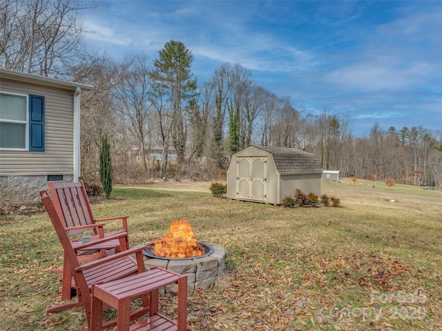 view of yard with a storage shed, an outdoor fire pit, and an outbuilding