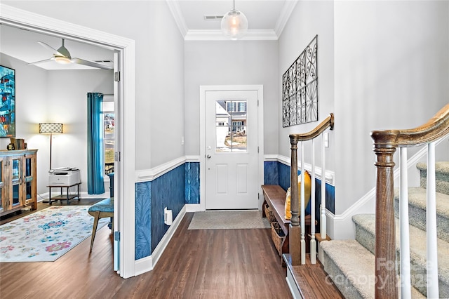 foyer entrance with ornamental molding, dark wood-style flooring, visible vents, and stairway