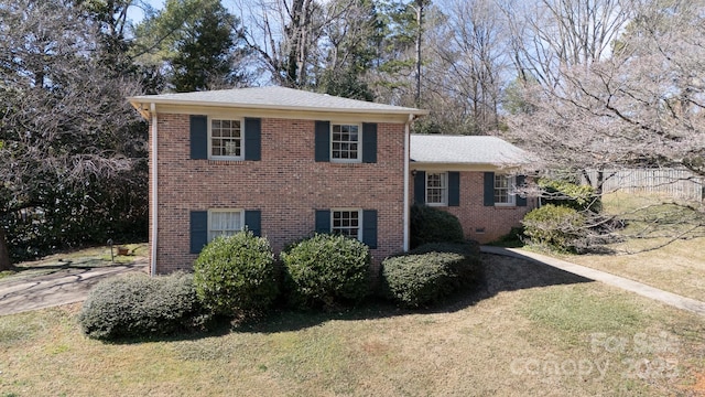 view of front of house featuring crawl space, a front yard, and brick siding