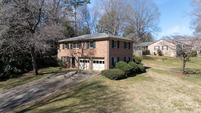 colonial-style house with an attached garage, aphalt driveway, a front yard, and brick siding