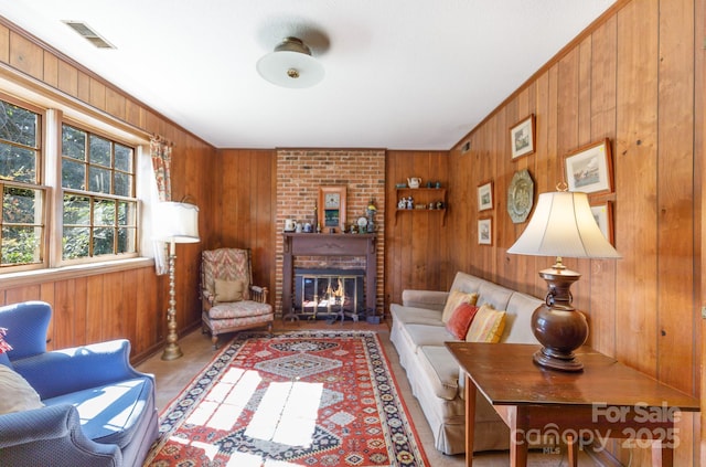 living room with visible vents, a fireplace, and wood walls