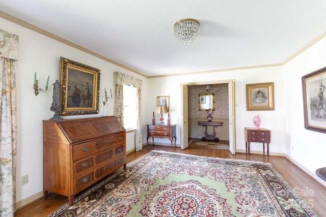 living area with crown molding, baseboards, and wood finished floors