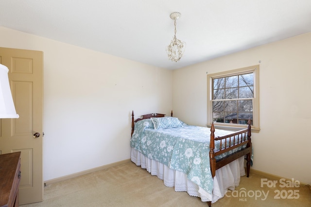 bedroom with baseboards, a notable chandelier, and light colored carpet