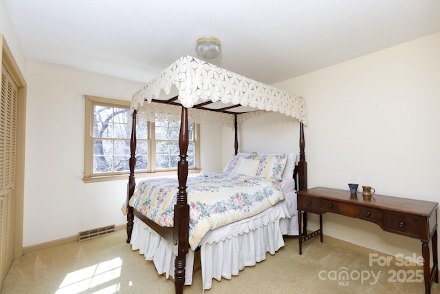 bedroom featuring baseboards, visible vents, and light colored carpet