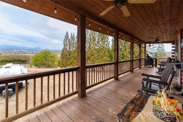 wooden terrace featuring a mountain view and a ceiling fan