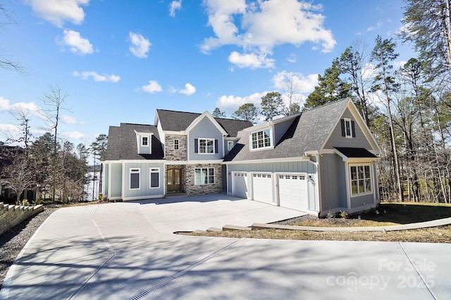 view of front of home with stone siding, roof with shingles, board and batten siding, and driveway