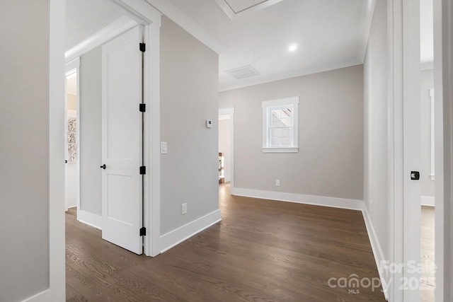 corridor with visible vents, baseboards, and dark wood finished floors