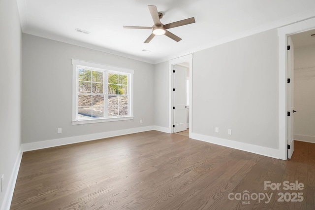 unfurnished room featuring visible vents, dark wood finished floors, a ceiling fan, and baseboards