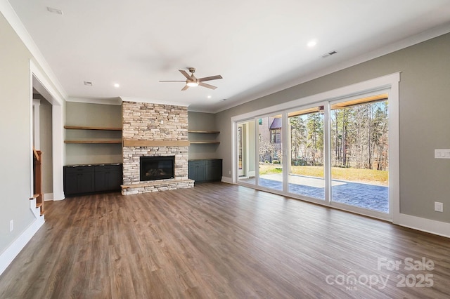 unfurnished living room with crown molding, a fireplace, wood finished floors, and baseboards