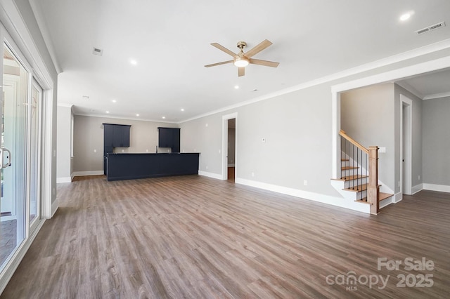 unfurnished living room with dark wood-style floors, visible vents, baseboards, and stairs