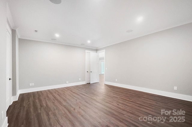 spare room with ornamental molding, recessed lighting, dark wood-style flooring, and baseboards