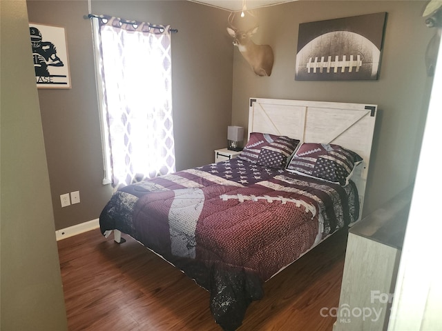 bedroom with wood finished floors and baseboards