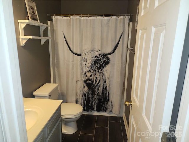 full bathroom with a shower with shower curtain, vanity, and toilet