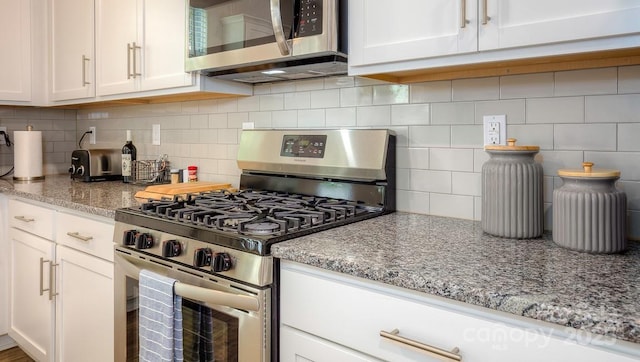 kitchen featuring appliances with stainless steel finishes, decorative backsplash, light stone counters, and white cabinets