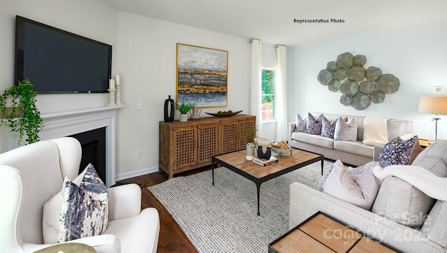 living room with a fireplace, wood finished floors, and baseboards