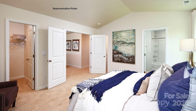 bedroom featuring a spacious closet, light carpet, baseboards, lofted ceiling, and visible vents