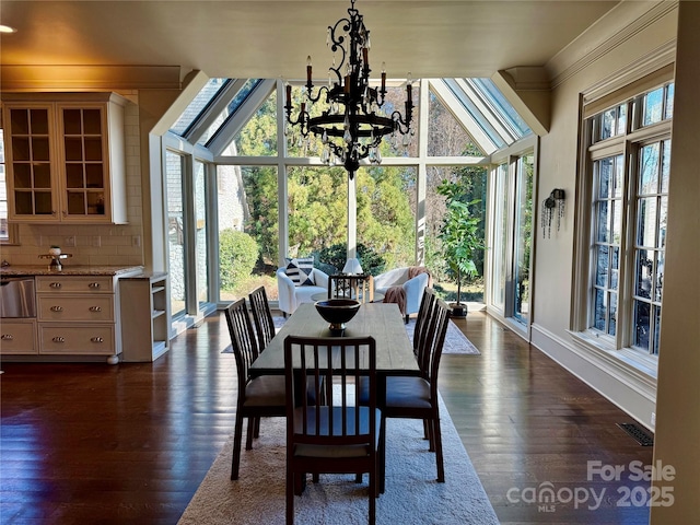 dining room with a chandelier, dark wood-type flooring, a wall of windows, and visible vents