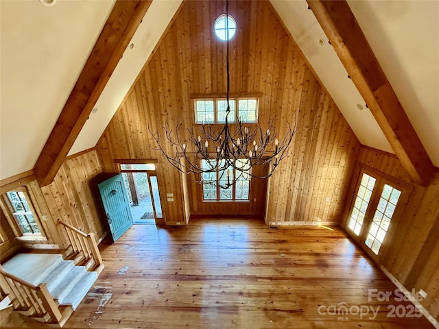 bonus room featuring a wealth of natural light, wooden walls, high vaulted ceiling, and wood finished floors