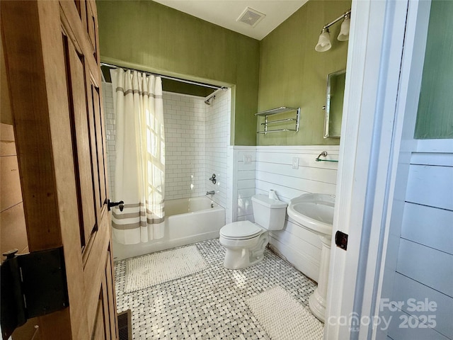 full bathroom featuring visible vents, a sink, shower / bath combination with curtain, and toilet