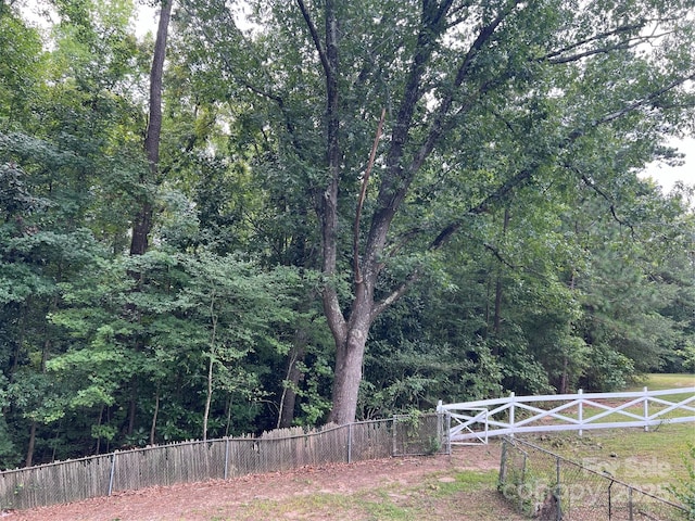 view of yard featuring fence and a view of trees