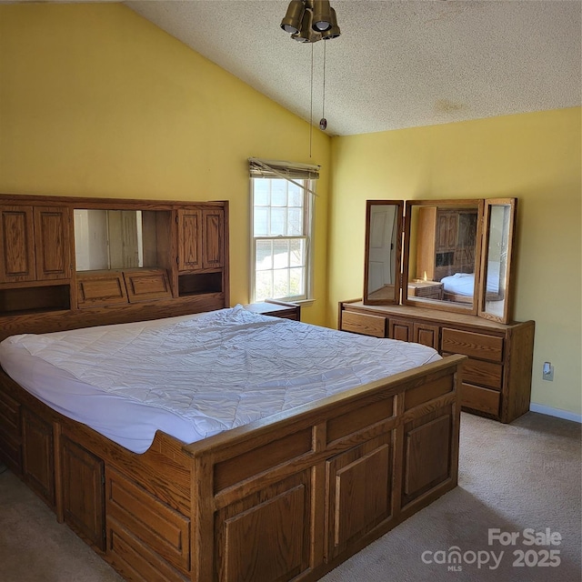 unfurnished bedroom with vaulted ceiling, a textured ceiling, and light colored carpet