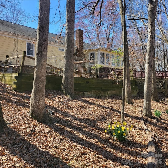 rear view of house with a deck and a chimney