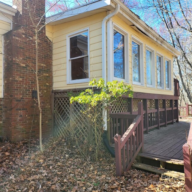 view of side of property featuring a deck and a chimney