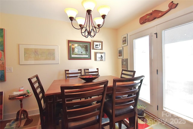 dining area with a chandelier and baseboards