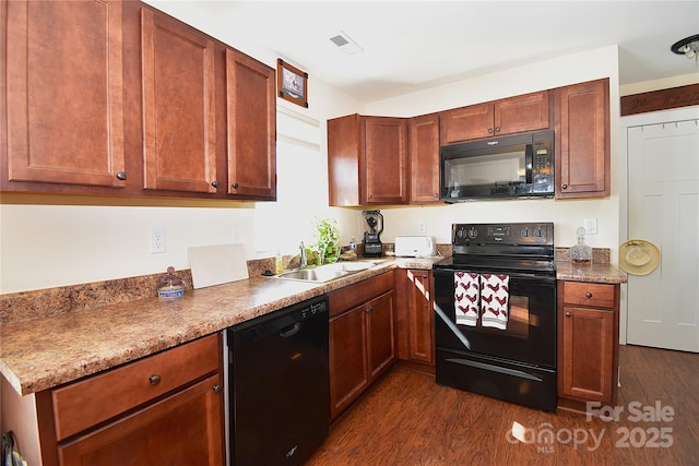 kitchen featuring black appliances, dark wood-type flooring, a sink, and visible vents