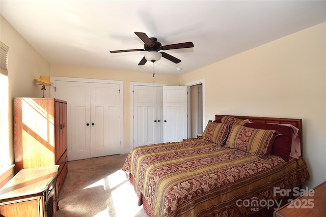 bedroom featuring multiple closets, carpet, and ceiling fan