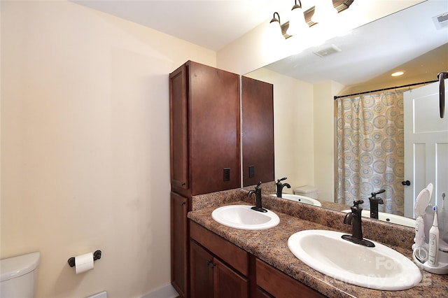 full bathroom with toilet, visible vents, and a sink