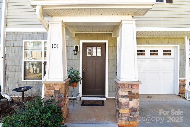 view of exterior entry with a garage and stone siding