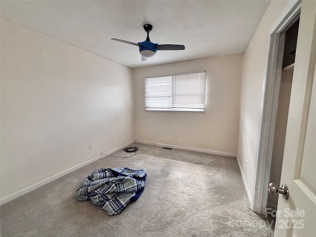 unfurnished bedroom with carpet, a ceiling fan, and baseboards