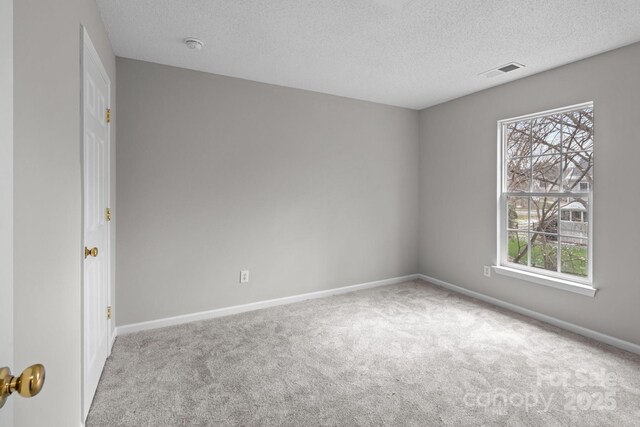 unfurnished room featuring light carpet, a textured ceiling, visible vents, and baseboards