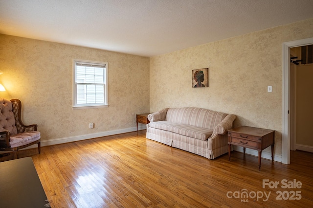 living area with baseboards and wood finished floors