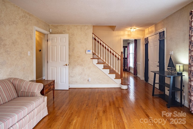 interior space with stairway, wood finished floors, and baseboards