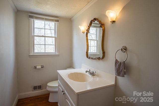 bathroom with visible vents, toilet, wood finished floors, a textured ceiling, and vanity